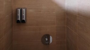A shower area with a glass-enclosed showerhead, a drain, and two soap dispensers labeled "BODY" and "HAIR". - MyRiverPlace N.5 - PORTO Riverfront Apartment With Breathtaking Views (Vila Nova de Gaia)