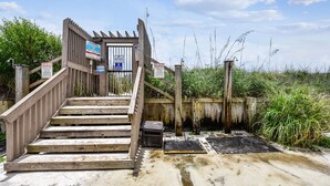 Een houten trap naar een toegangspoort met informatietekens.