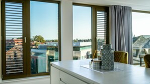 Una cocina moderna con ventanas amplias, una encimera blanca y vistas a la ciudad.