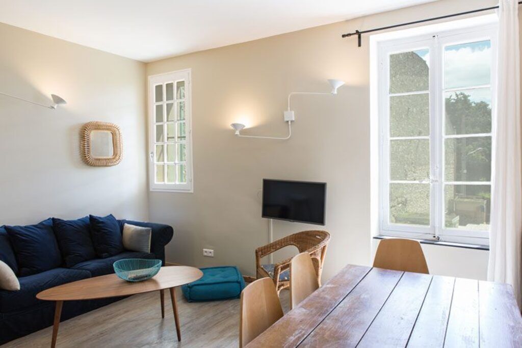 Un salon confortable avec un canapé, une table et un téléviseur.