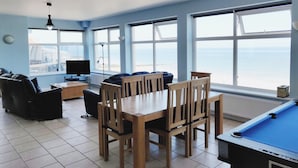 A room with a pool table, a TV, and a view of the sea. - The Plaice -  Wake up to panoramic sea views in The Plaice, Sheringham (Sheringham)