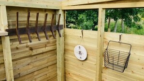 A wooden structure with a metal rack for hanging items and a metal basket. - Private Glamping in a Vintage Caravan & Bell Tent (Morpeth)