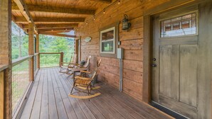 A wooden porch with rocking chairs and a door. - Cozy Cabin, Great Location, Close to downtown, Private Hot Tub. (Gatlinburg)