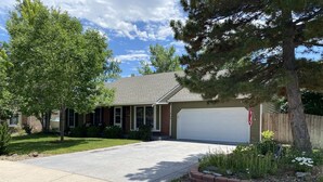 A single-story house with a front garage, a well-maintained lawn, and mature trees. - Spacious 5 bedroom house minutes from Red Rocks (Littleton)