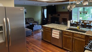 A kitchen with a built-in dishwasher, wooden cabinets, a granite countertop, and a large window. - Spacious 5 bedroom house minutes from Red Rocks (Littleton)