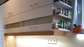 Una cucina moderna con lavatrice integrata, macchina del caffè e ripiano con utensili da cucina.