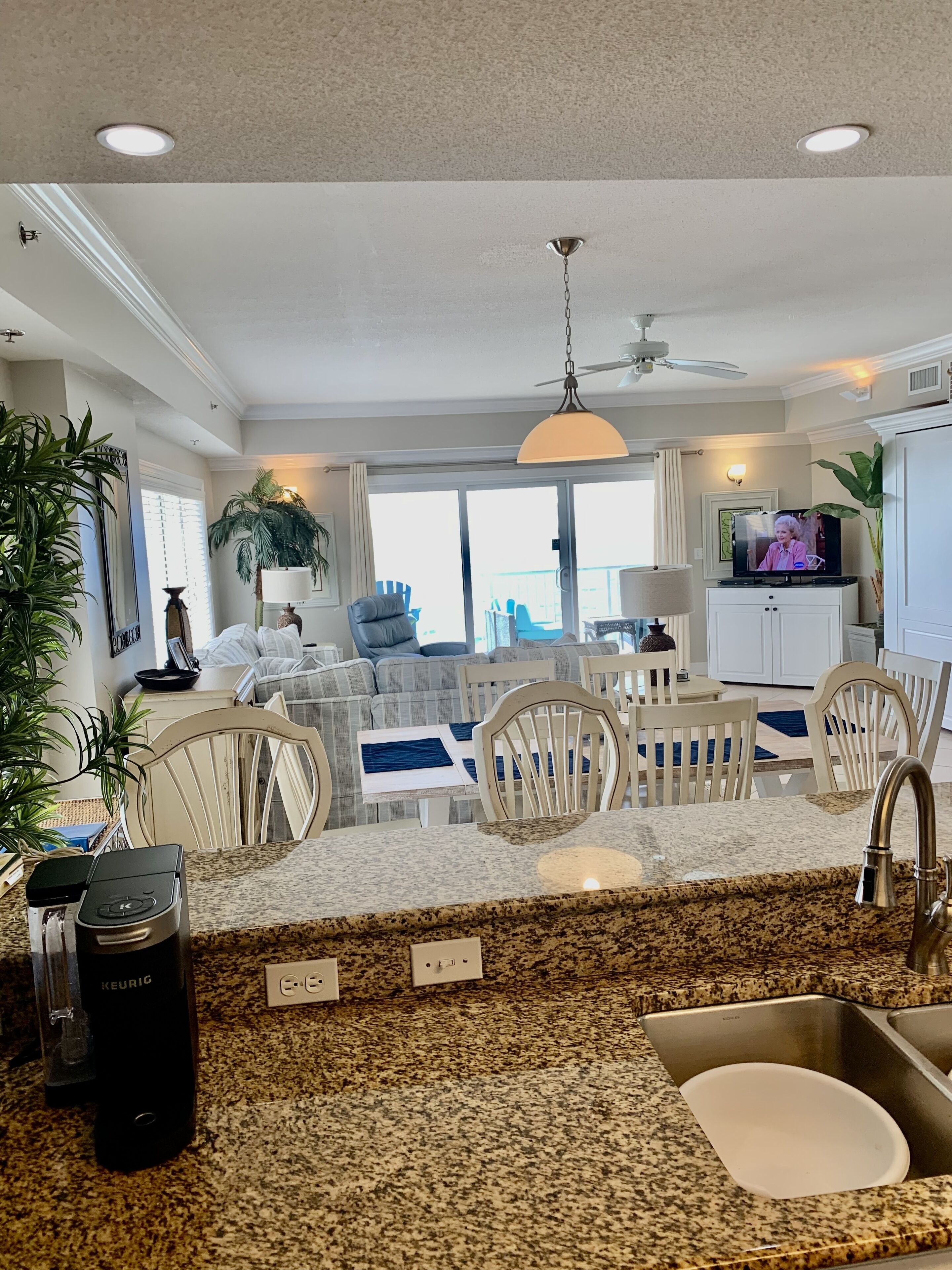 A modern kitchen with granite countertops, a built-in sink, and a coffee maker.