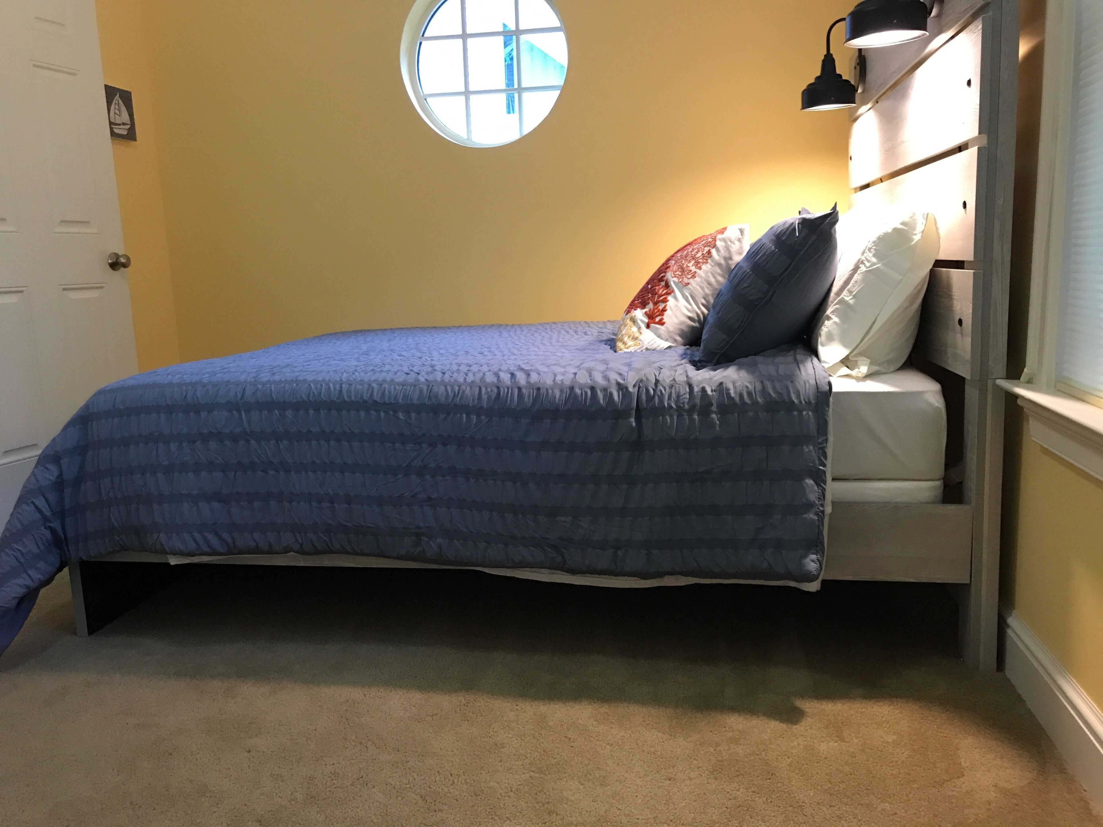 A bedroom with a bed, a window, and a door.