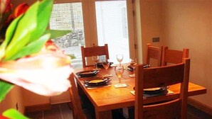 Une table à manger dressée avec des assiettes, des verres et des couverts.