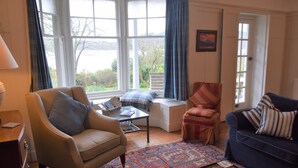 A cozy living room with a sofa, armchair, and a bench by the window. - Elm Cottage -  a house that sleeps 8 guests  in 4 bedrooms (Dalbeattie)