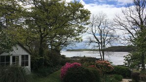 A garden with a pond, a white building, and a view of the water. - Elm Cottage -  a house that sleeps 8 guests  in 4 bedrooms (Dalbeattie)