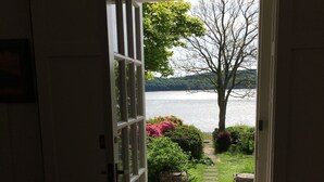 An open door leading to a stone pathway with a view of a lake and a tree. - Elm Cottage -  a house that sleeps 8 guests  in 4 bedrooms (Dalbeattie)