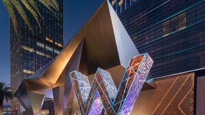 A modern building with a unique geometric facade and illuminated neon lines.
