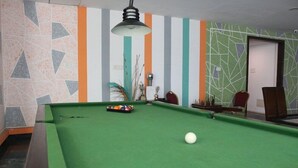 A pool table with balls, a lamp, and striped walls. - Citrus Hotels Sriperumbudur (Sriperumbudur)