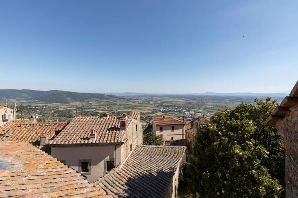 A view of terracotta-roofed buildings with a distant landscape.