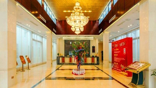 A spacious lobby with a chandelier, a reception desk, and a red informational sign. - Ji Bin Hotel (Changsha)