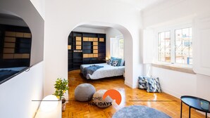 Un intérieur moderne avec un lit, un plancher en bois et une grande fenêtre.