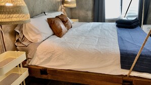 A bed with white and brown pillows, a wooden headboard, and a hanging rattan lamp. - Stay at the Lazy Llama House with Self Check-In (Lincoln)