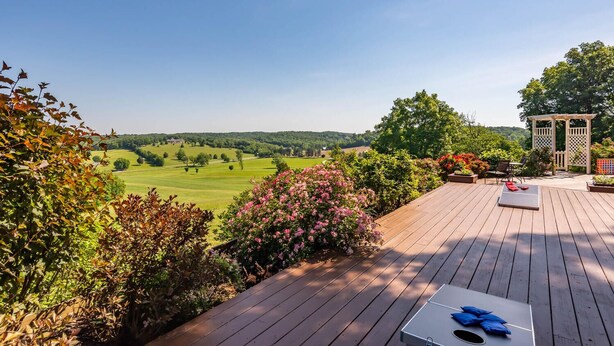 A wooden deck with a view of a golf course, a gazebo, and surrounding greenery. - Beautiful New Cottage w/ Endless Hilltop Views (Paoli)