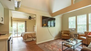 A spacious living area with a large flat-screen TV mounted on the wall, a comfortable sofa, a coffee table, and a patterned rug. - Beautiful New Cottage w/ Endless Hilltop Views (Paoli)