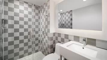 A modern bathroom with a shower, toilet, and sink.