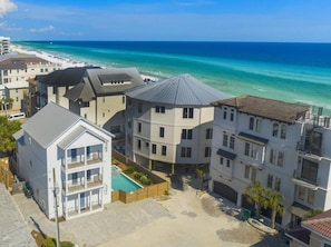Un quartier résidentiel situé sur la côte, avec des immeubles à plusieurs étages, une piscine et une vue sur la plage.