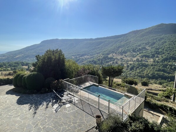 A pool area with a view of a mountainous landscape. - Gîte in Ardèche with swimming pool and magnificent view of the valley (Rochessauve)