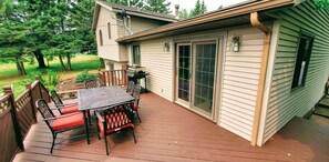 A house with a deck, a barbecue grill, and a sliding glass door.