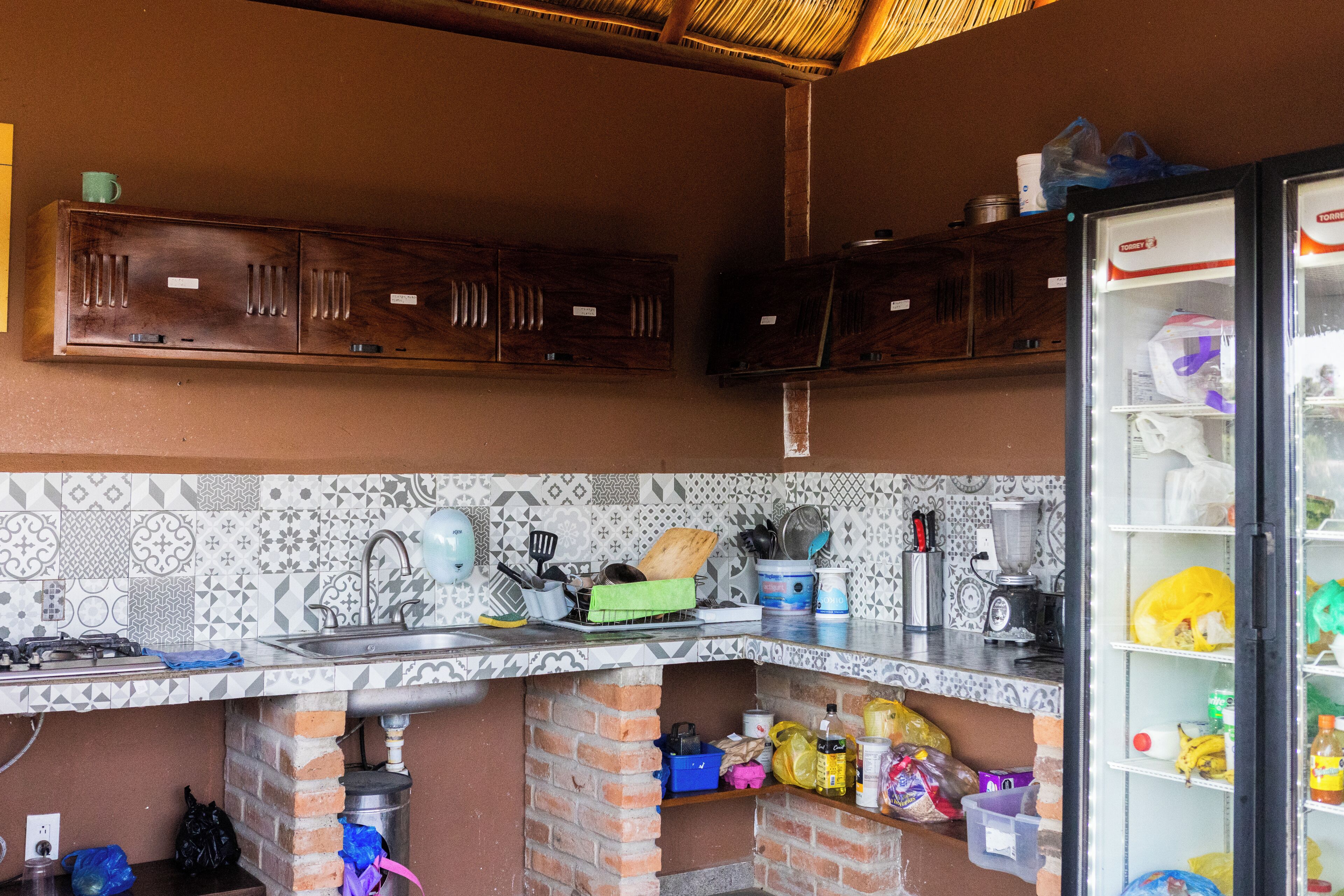 Eine Küche mit gefliestem Rücksprung, Spüle, Herd und Kühlschrank.
