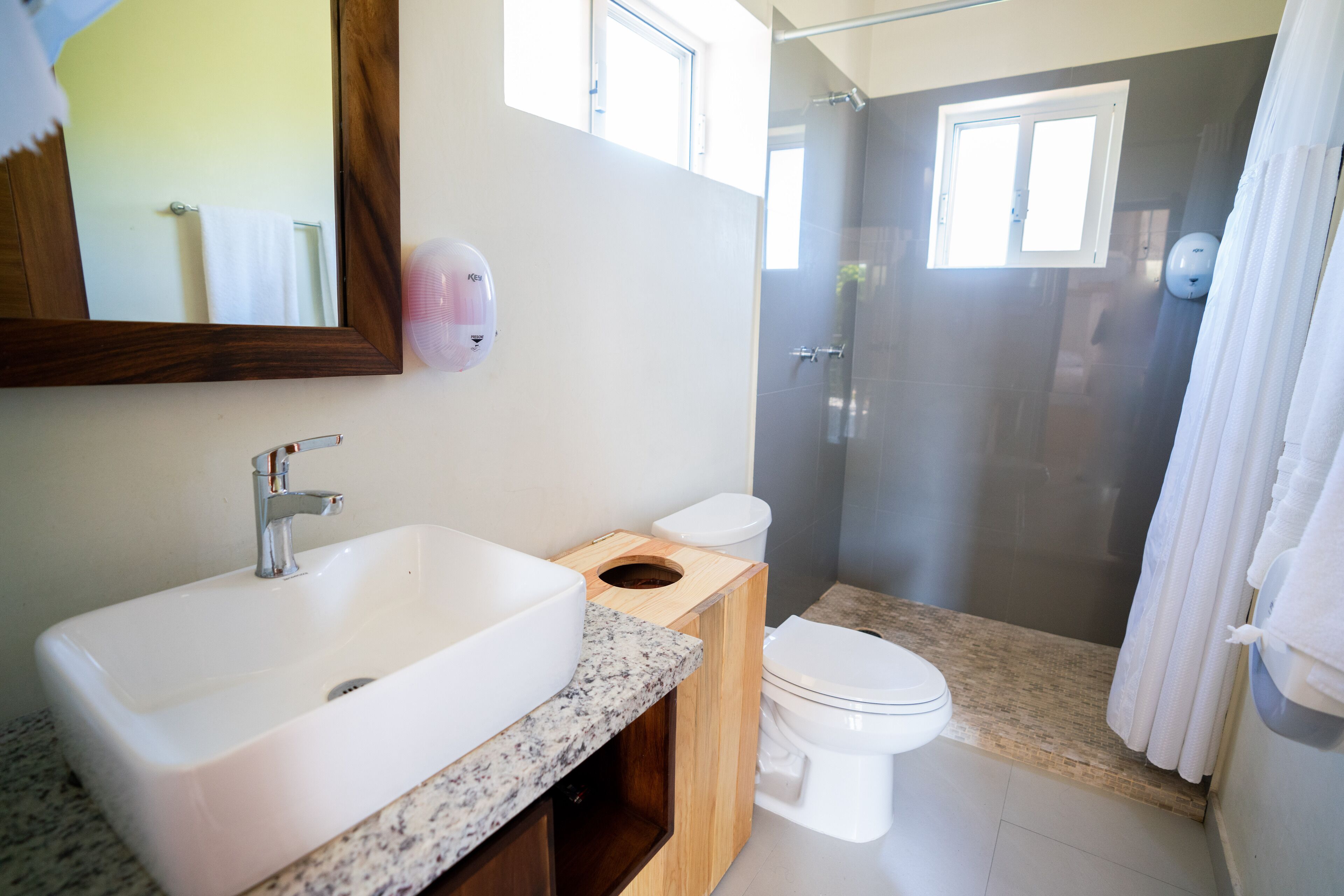 Une salle de bain avec un grand lavabo, des toilettes et un espace douche.