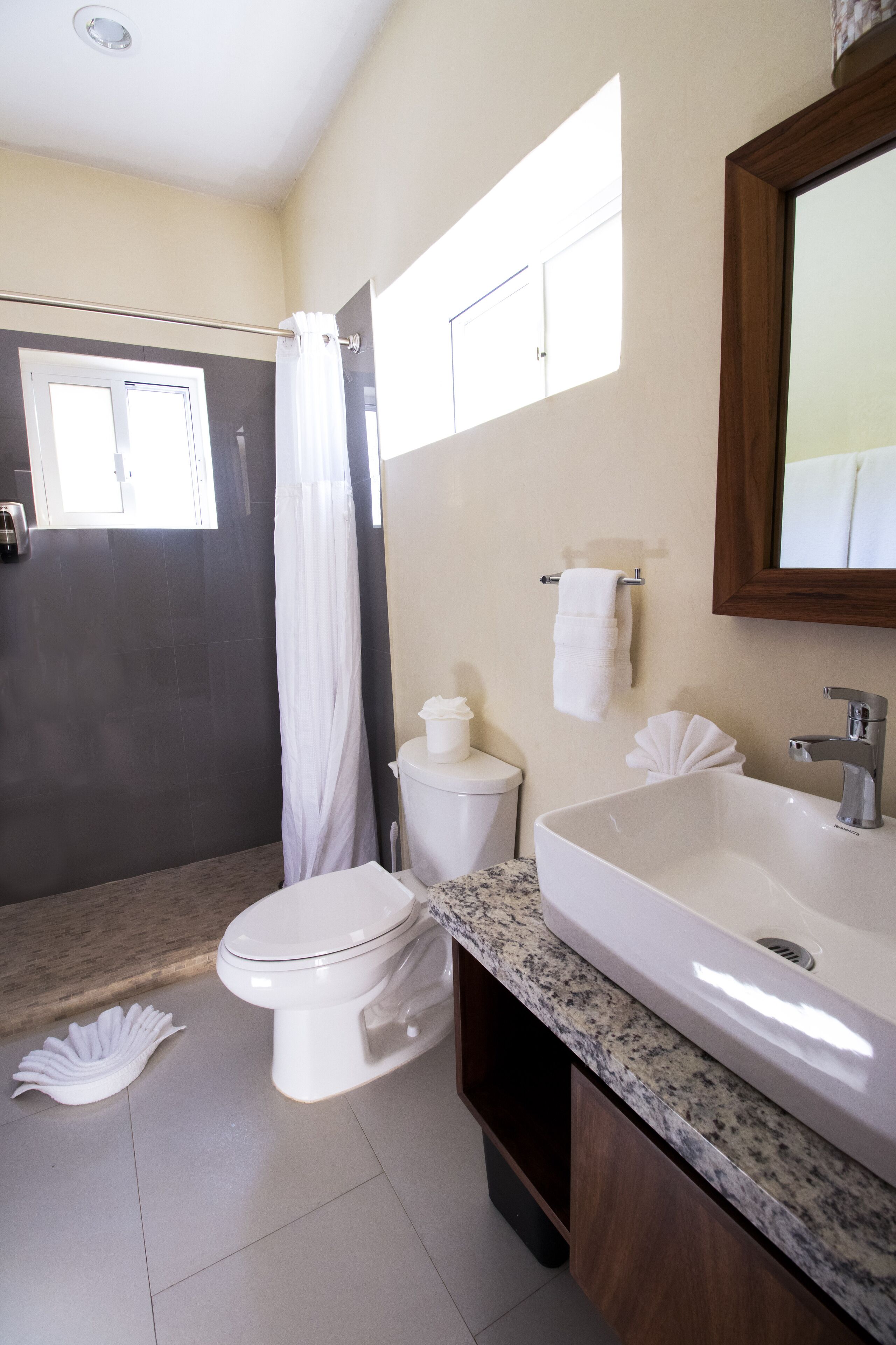 Un baño con inodoro, lavabo y ducha.