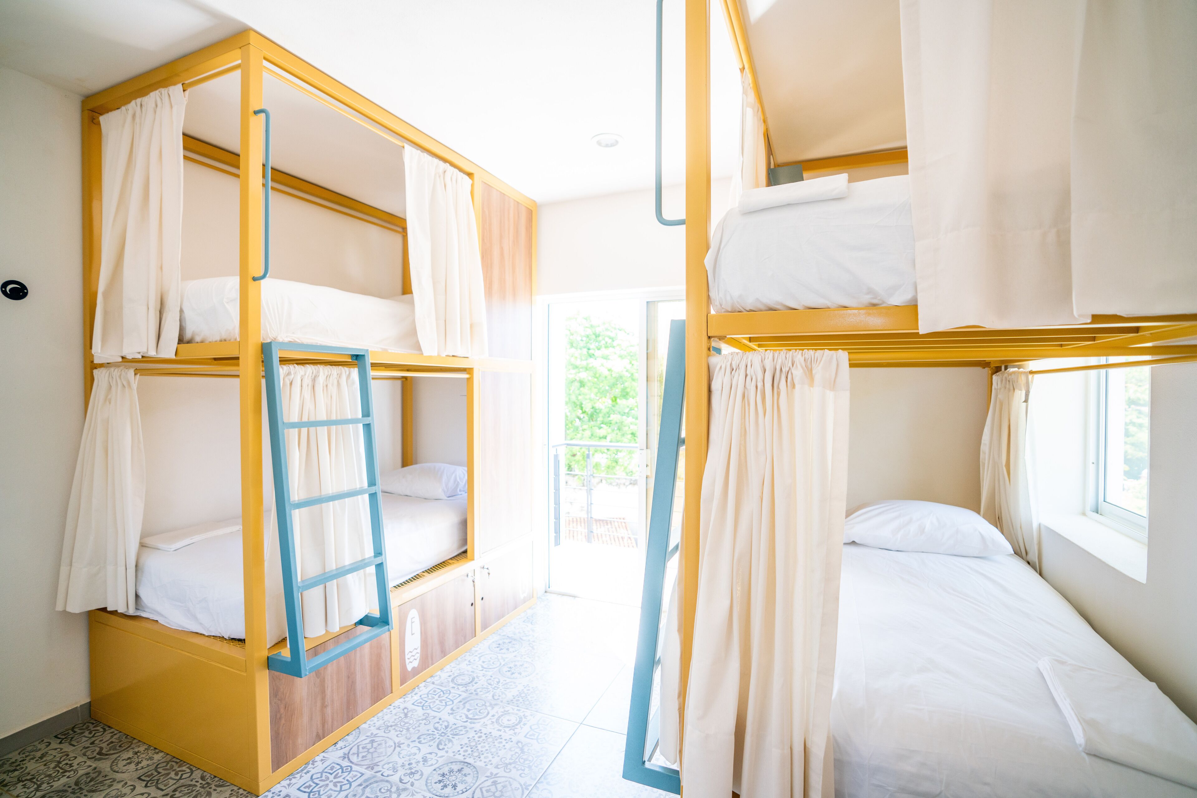 Un dormitorio con literas, una escalera y una ventana.