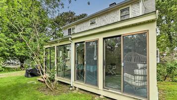 A house with large glass windows and a covered porch.