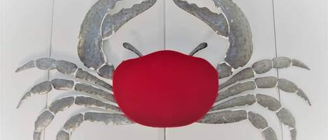 Une décoration en forme de crabe, avec un centre rouge sur un fond blanc.