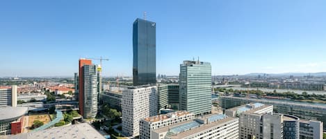 A cityscape with modern high-rise buildings, including a prominent skyscraper with a glass facade.