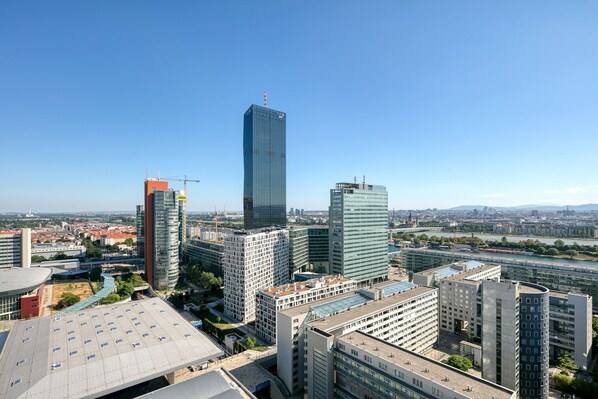 A cityscape with modern high-rise buildings, including a prominent skyscraper with a glass facade.