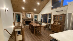 Una cocina amplia con una isla grande, piso de madera y chimenea de piedra.