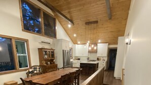 Una cocina amplia con suelo de madera, armarios blancos y una isla central.