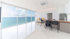 A modern kitchen with a view of the ocean, a dining area with chairs, and a small table. - Daytona Pool Villa (Pohang)