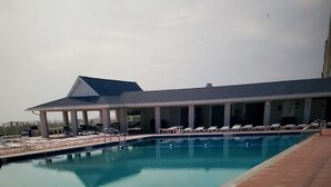 A swimming pool with a covered area and lounge chairs. - Beach house within walking distance to the beach  2 bed 2 bath (Jensen Beach)
