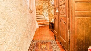 A narrow hallway with a stone wall, a wooden door, and a staircase leading to a higher level. - Vacation home La Roq by Interhome (Roquebrune sur Argens)