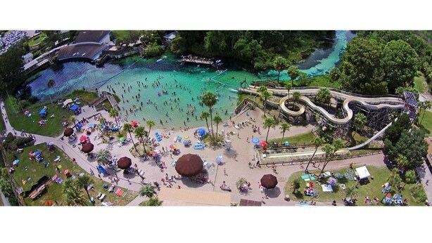 An aerial view of a beach area with a roller coaster, palm trees, and people enjoying the water. - Beautiful 2Bed,2Bath,2Car Garage Stunning Cul-de-sac property on 2 acres Estate (Spring Hill)