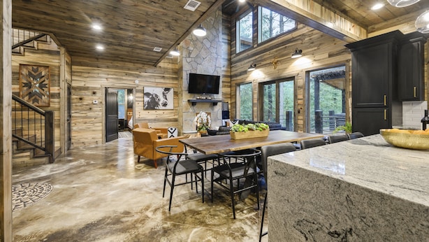 A spacious kitchen with a stone accent wall, a large island, and black cabinetry. - BRAND NEW! Smokey Pines |  BOHO Modern + Chic Contemporary | Sleeps 12 (Broken Bow)