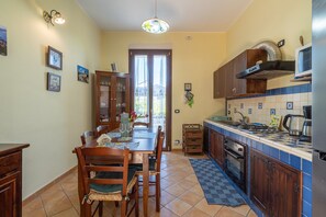 A kitchen with a dining table, chairs, a stove, oven, and a microwave.