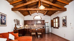 A kitchen with wooden cabinets, a dining table, and chairs. - Holiday Home "Asfodeli" with Wi-Fi, A/C & Garden (Teulada)