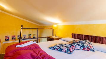 A room with a bed, a nightstand, a lamp, and posters on the wall.
