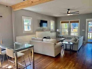 Relax in this open-plan living space with a large sofa, dining area, and flat-screen TV.