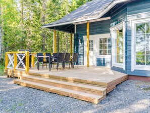Eine Holzterrasse mit Sitzgelegenheiten im Freien und einem überdachten Bereich.