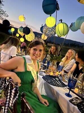 A table set with blue glassware and candles, surrounded by decorative paper lanterns.