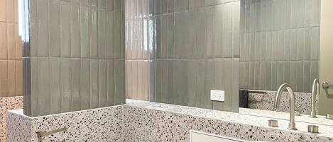 A modern bathroom with a freestanding bathtub, a white sink, and a toilet.